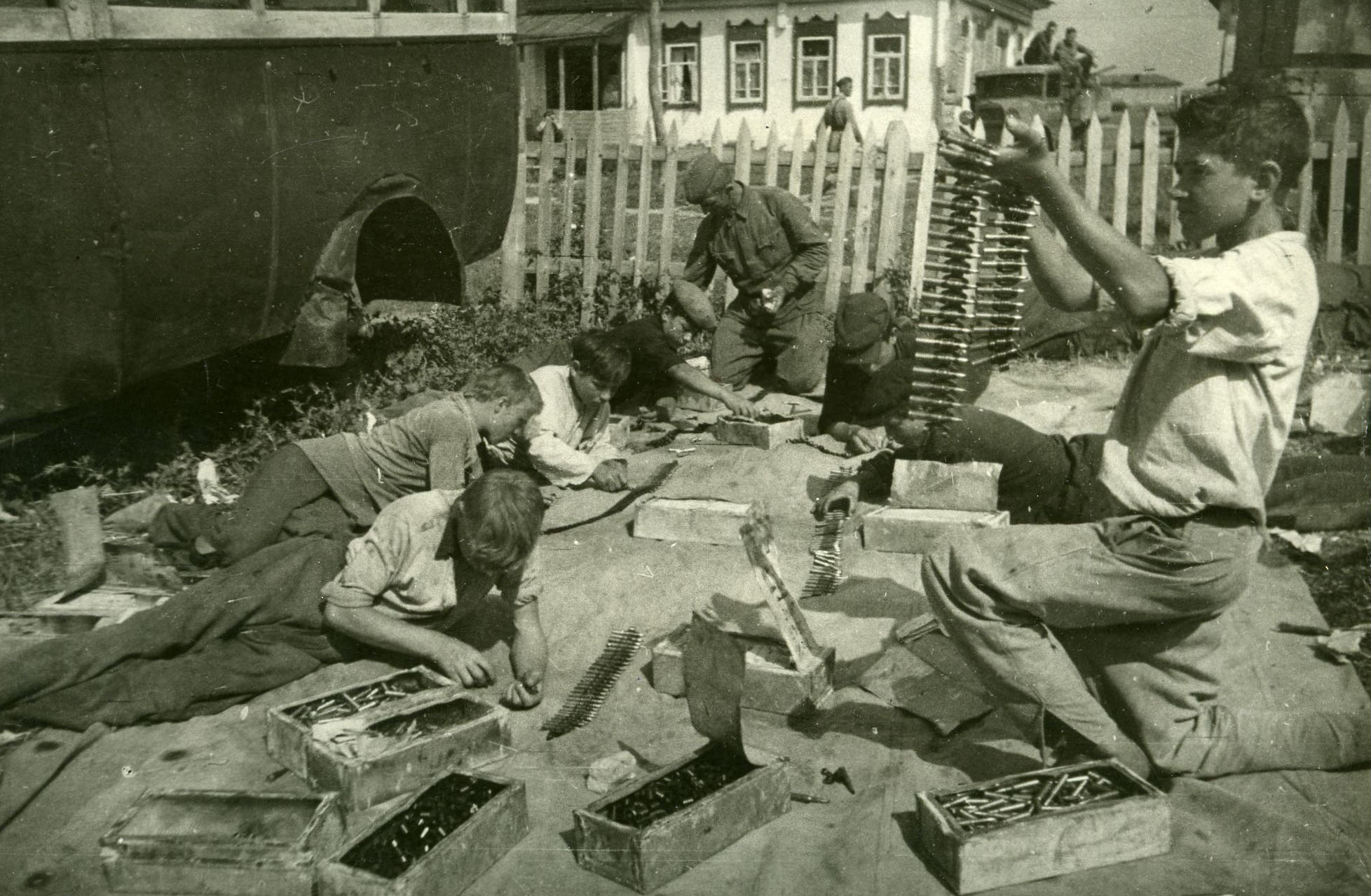Школьники на Н-ском аэродроме набивают патроны в ленты. Прифронтовое село, июль 1942 г.