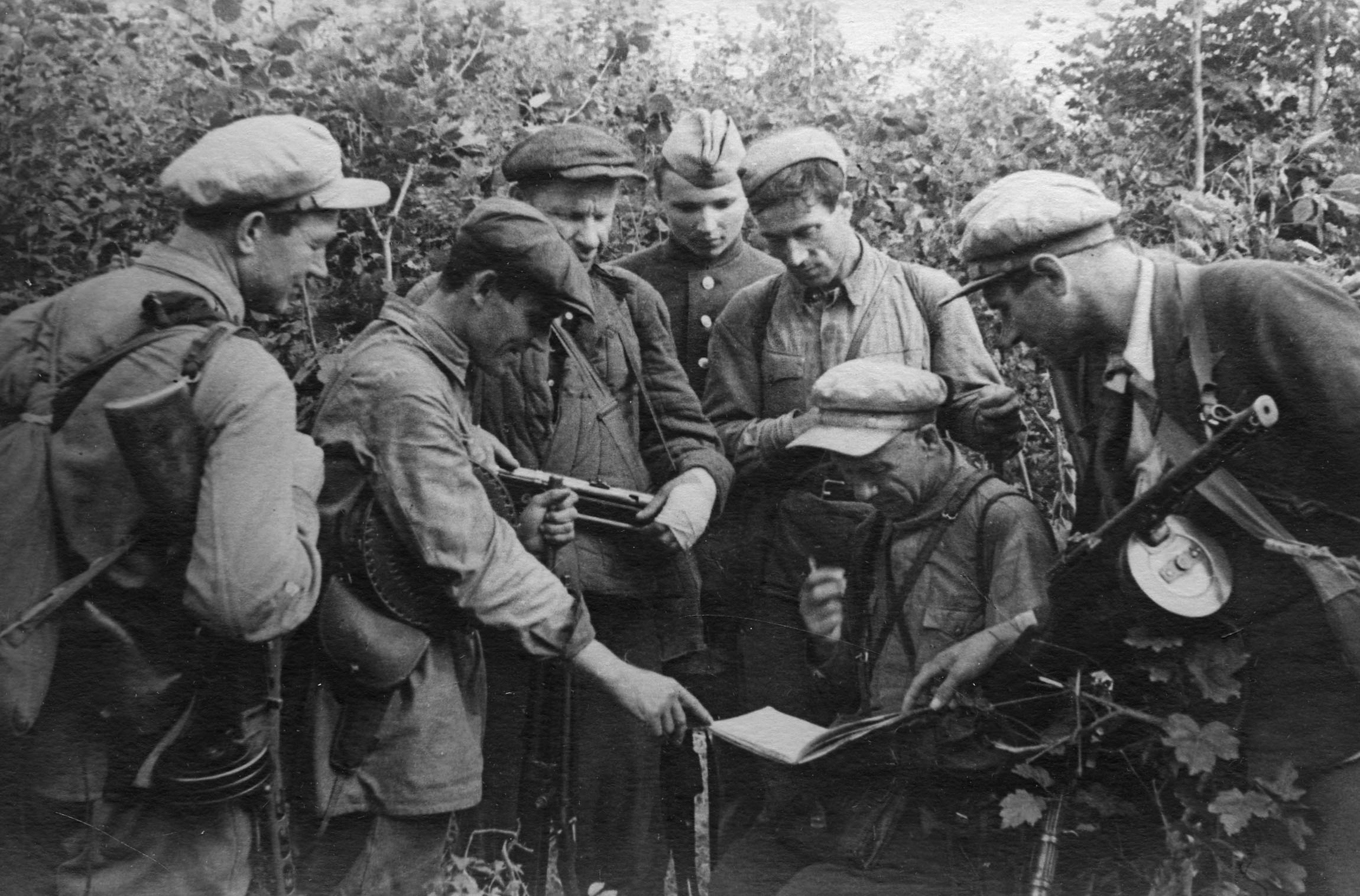 Партизаны рассматривают перехваченный документ немецкого штаба. Орловская область, 1942 г.